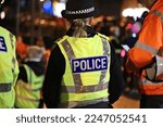 Police officer in hi-visibility jacket policing crowd control at an outside UK event