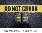 Do not cross line child in sneakers standing next to a yellow line with restriction or safety warning
