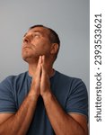 Small photo of Concerned middle aged male looking up in a praying pose emphasizing his religiosity and spirituality