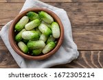 Small photo of Small fresh snack cocktail Dutch cucumbers Quirk variety on wooden background, healthy vegetarian organic food concept