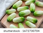 Small photo of Small fresh snack cocktail Dutch cucumbers Quirk variety on wooden background, healthy vegetarian organic food concept