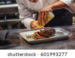 Chef In Restaurant Arrangin And Decorating Food