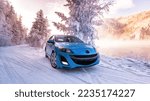 Small photo of Nelson, British Columbia, Canada - December 05, 2022 Mazda 3 bl blue, in winter on the lake, in the white snow