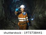 Miner in the mine. Well-uniformed miner inside mine raising thumb, conceptual photo