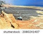 Small photo of Masada, Israel - OCTOBER 19, 2018: Cable car transporting tourists to the ruins of the zealot fortress. Masada National Park in the Dead Sea region of Israel.
