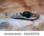 Small photo of Burned tea kettle, glass, and other utensils of a nomadic cave dweller, bedouin in Petra Jordan Antique city featured in Indiana Jones