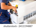 Air conditioning technicians install new air conditioners in homes, Repairman fix air conditioning systems, Male technician service for repair and maintenance of air conditioners	