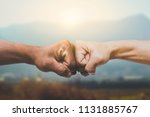 Man giving fist bump in sun rising nature background. power of teamwork concept. vintage tone