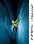 Small photo of Athlete ice climbing inside a crevasse at night, lit by artificial light as he climbs from the dark crevasse.