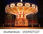 Illuminated swing chain carousel in amusement park at night