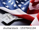 USA national flag and currency usd money banknotes on dark background. Business and finance concept