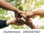 Small photo of 4 people join forces, the concept of hand-to-hand to create unity, group of people, hands, teamwork business group by reaching out in a circle The power of work is friendship with business colleagues.