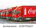 A Row Of Coca Cola Trucks In...