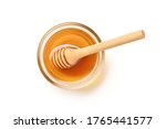 Flat lay (top view) of Glass bowl of pure honey with honey dipper isolated on white background. Clipping path.