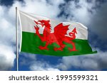 Wales flag on sky and cloud background. National symbols of Wales. Flag of Wales.