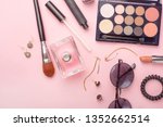 Small photo of Beauty blog fashion concept. Female style of accessories: cosmetics, glasses, perfumes, eye shadows, tush on a pink background. Flat lay, top view fashionable female background. Flat lay
