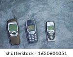 Small photo of Bangkok, Thailand - January 20, 2020: Vintage of three popular Nokia mobile 90’s on grey table in use shop. Classic model. 7710, 3310 , 8310.