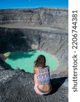 Small photo of A girl looks at a volcanic lake at the top of the Santa Ana volc