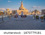 Small photo of Doha, Qatar-December 2 2020: Al-Fanar Qatar Islamic Cultural Center daylight exterior view with clouds in sky in background and traditional policemen riding horses in foreground