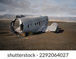 The wreckage of a DC-3 airplane on the black sand beach of Sólheimasandur.  Remote location of the crash site, along with the stark contrast of the rusted metal against the black sand