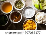 Small photo of selection of ingredients in white ramekins for mango syllabub including fresh fruit, spices, cream and icing sugar