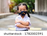 Asian pre kindergarten children wearing a protection mask for prevent the spread of the Covid-19 standing outdoor, Covid-19 virus protection concept in Thailand.