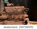 Small photo of Man building with his hands an adobe house with adobe bricks and mud. Llachon region of Lake Titicaca in Peru.