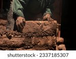 Small photo of Man building with his hands an adobe house with adobe bricks and mud. Llachon region of Lake Titicaca in Peru.