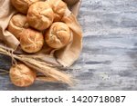 Crusty round bread rolls, known as Kaiser or Vienna rolls on linen towel, flat lay on rustic background with text space
