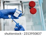 Small photo of Gynecologist is holding flask for cytology Pap smear test in hands. Gynecological cytology Pap smear test and cytobrush in hands of gynecologist