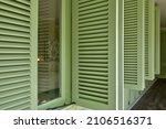 Small photo of Unique green wooden shutters are opening