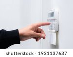Hand entering alarm system password of an apartment, home or business office. Surveillance and protection console against rubbery and thief