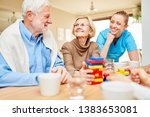 Small photo of Nursing care takes care of demented senior citizens playing with building blocks