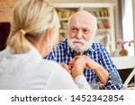 Small photo of Doctor or nursing wife consoles demented senior on home visit