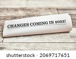 Small photo of Changes coming in 2022 is written on the front page of a folded newspaper on a wooden table