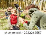 Small photo of Teacher and child from the forest day-care center with seedling during tree science lessons as forest pedagogy