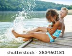 Two kids splashing water with their feet in summer
