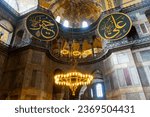 Small photo of ISTANBUL, TURKEY - Mai 19, 2023: tourists walking under chandelier in Aya Sophya mosque. Inside Hagya Sophya mosque in Istanbul. Window and wall of Aya Sophya