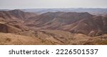 Small photo of Morning view over a dry wadi in a nature reserve in the Judean desert near city Arad, Israel. Panoramic desert landscape and foggy haze over mountains hills and sandy folds.