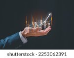 investment and finance concept, businessman holding virtual trading graph and blurred coins on hand, stock market, profits and business growth.