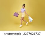 Small photo of Cheerful happy teen asian woman enjoying shopping, she is carrying shopping bags and jumping to get the latest offers at the shopping center.