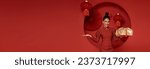 Happy smiling Asian woman in red traditional costume giving gold gift box on decoration traditional for chinese new year header copy space background.