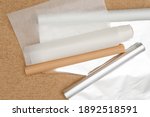 Small photo of Different type of paper for baking needs. Parchment paper, foil, wax paper close up on rustic background, flat lay
