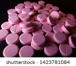 Small photo of Pink Nitroglycerin pills scattered on solid black background - 005