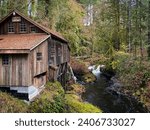 Small photo of Old historic Cedar Creek Grist Mill at a small creek flowing betweenthe trees of the forest at woodland, WA, USA.