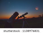 Small photo of Girl looking at lunar eclipse through a telescope. My astronomy work.