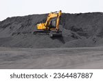 Small photo of A backhoe - excavating equipment, Digger working on the bulk mountain of coal imported at Dindayal Port Trust, Kandla. Gujarat - India
