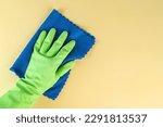 Green rubber gloves and a micro fiber towel, cleaning and housekeeping concept, copy space for infographics
