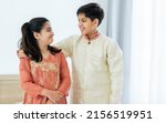 Small photo of Portrait two people Indian siblings, brother, sister hugging with warmth, love, wearing traditional clothes, smiling with happiness in cozy indoor home. Family, Education, Lifestyle Concept