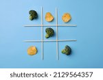 Small photo of A game of TIC-tac-toe between healthy and unhealthy food. Choose between chips and broccoli. The victory of healthy eating